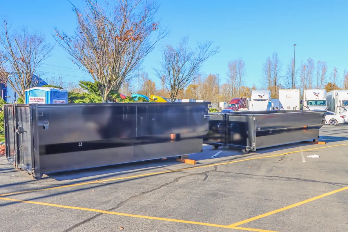 Professional dumpster rental service with roll-off container on residential driveway in Thetford